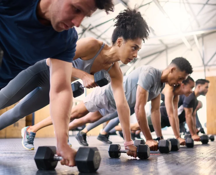 people perform renegade rows inside a gym